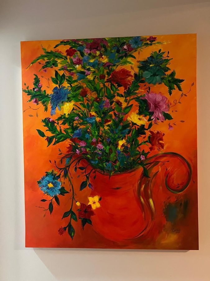 Tela de um vaso vermelho com um buquê de flores coloridas sobre fundo laranja, pendurada numa parede branca.